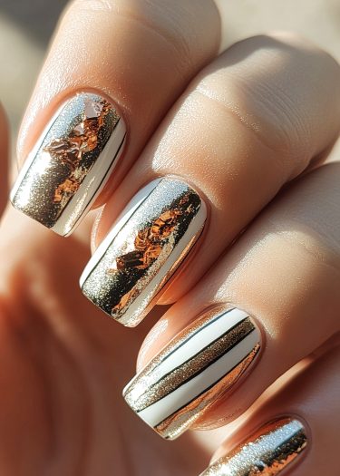 Stunning elegant chrome nail design with metallic gold and chic contrasting patterns.