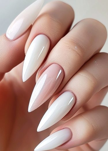 Elegant stiletto white manicure with a sparkling pink accent nail for a luxurious look.