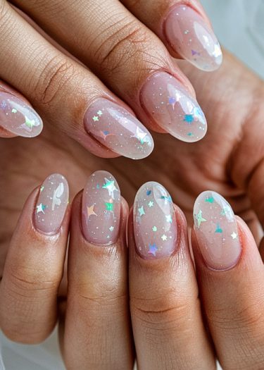 Elegant clear nails with iridescent star embellishments for a chic and whimsical manicure.