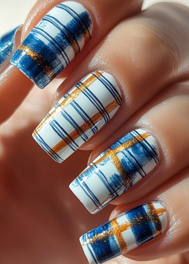 Elegant plaid nail art in blue, gold, and white with a glossy finish.