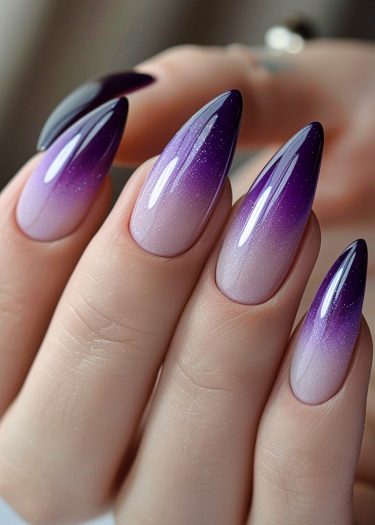 Elegant almond-shaped nails with a stunning pink-to-purple gradient and sparkling glossy finish.