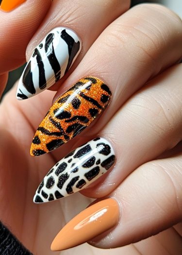 Creative stiletto animal print nail art featuring zebra, tiger, and giraffe patterns with vibrant colors.