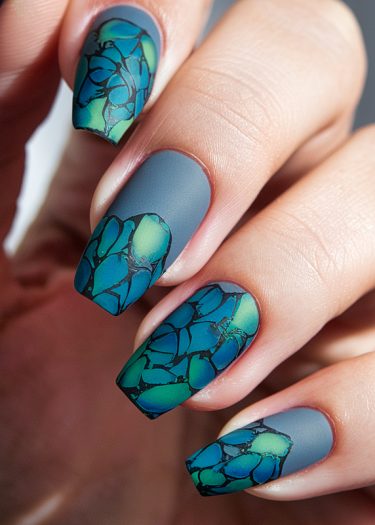 Elegant blue-gray nails with vibrant stained glass designs for sophisticated nail art inspiration.