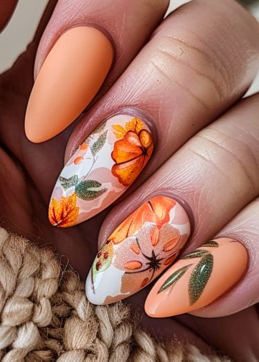 Elegant autumn floral nail design featuring detailed flowers in soft orange tones.