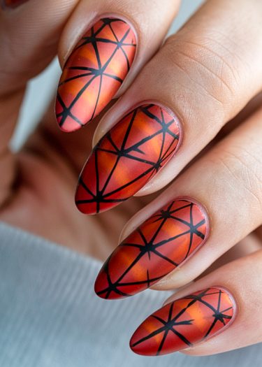 Artistic autumn gradient manicure with bold geometric patterns on almond-shaped nails.