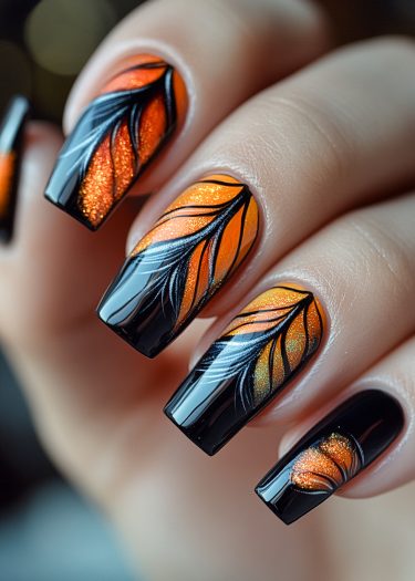 Stunning autumn leaf nail art features black and orange gradient with glitter detailing.