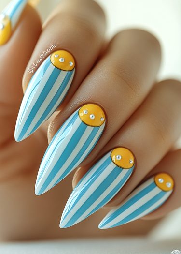 Elegant almond-shaped nails with azure stripes and yellow accents, featuring embellishments for a chic look.