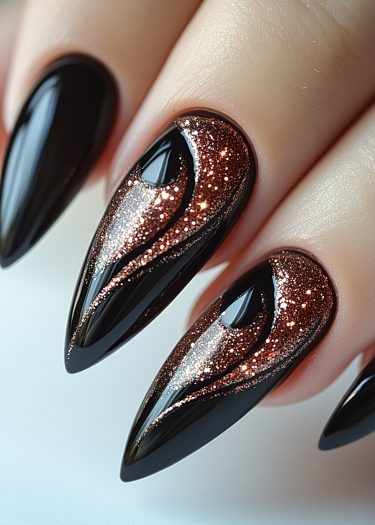 Stiletto nails with black base and shimmering copper glitter create a bold, stylish look.