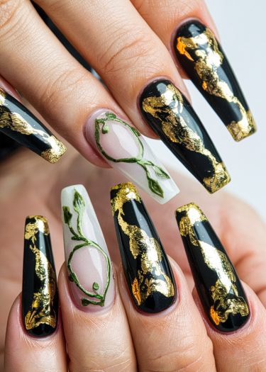 Elegant black and gold nail art with intricate green vines for a modern, luxurious look.