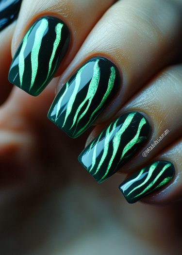 Bold black and green tiger stripe nail art design with glossy finish and metallic details.