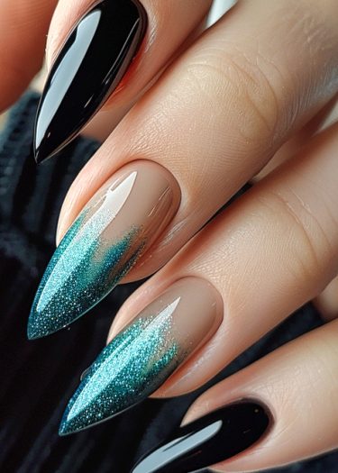 Elegant black and teal nail art with ombre and glitter on almond-shaped stiletto nails.