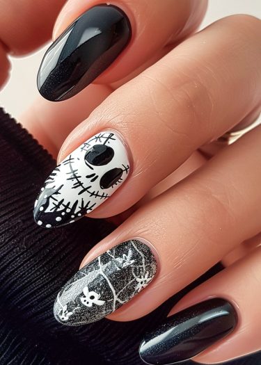 Halloween-themed black and white nail art featuring skulls, ghosts, and spiderwebs for festive flair.