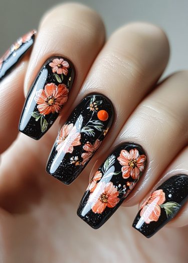 Elegant black floral nail art with vibrant pink and orange daisies and shimmering glitter.