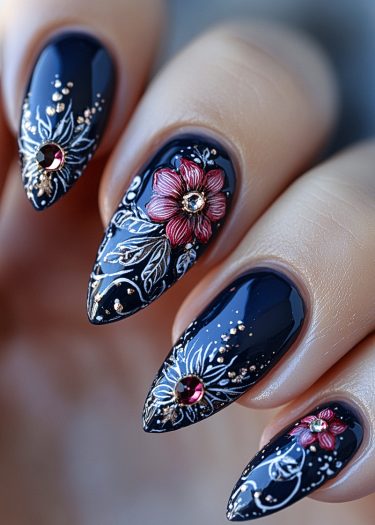 Elegant black nail art with floral designs, featuring burgundy flowers and golden accents.