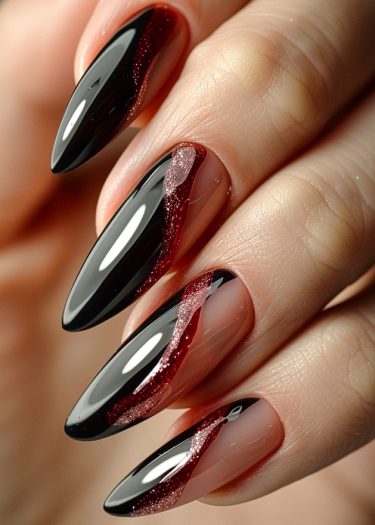 Elegant stiletto nails with black and glittery red design for a dramatic fashion statement.