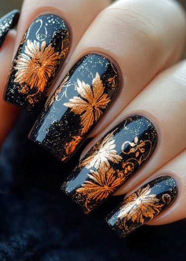 Elegant black and gold floral nail art design on glossy long nails.