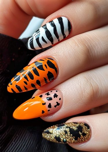 Vibrant animal print nail art design featuring zebra, tiger, and glamorous black-gold glitter.