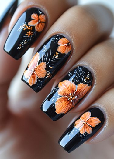 Elegant black hibiscus nail art with vibrant floral designs in orange and peach tones.