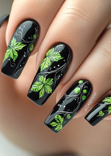 Elegant black nail art with intricate green leaf designs and white vine accents.