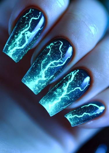 Stunning navy blue lightning nail art with glowing teal accents and sparkling glitter details.