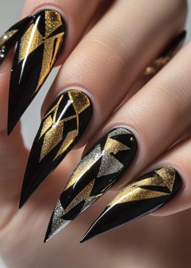 Sleek black stiletto nails with metallic gold and silver geometric patterns for bold elegance.