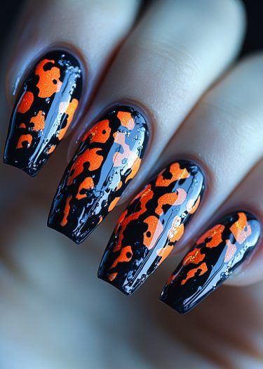 Glossy black and orange leopard print nail art for bold, trendy style.