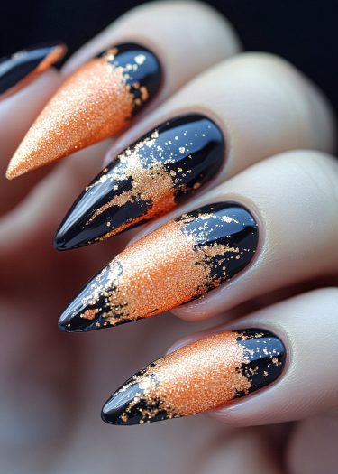 Stunning stiletto nails with glossy black and vibrant orange-gold glitter design.