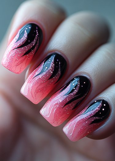 Vibrant black and pink flame nail art with glitter, showcasing bold, modern design.