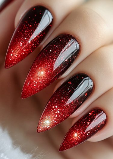 Stunning stiletto nails with black-red gradient and sparkling glitter for a glamorous manicure.