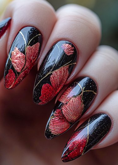 Elegant long black nails adorned with red flowers and gold accents for stunning nail art.