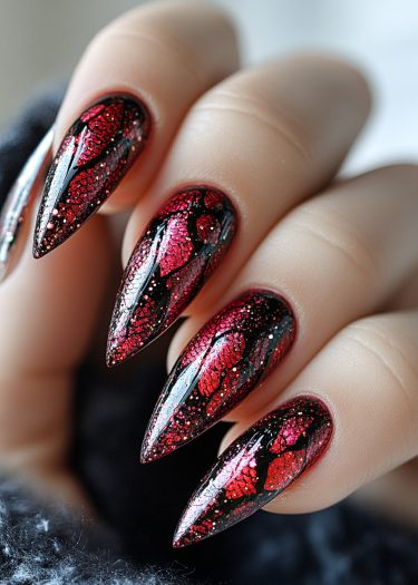 Elegant black stiletto nails with vibrant red glitter leaf designs for stunning nail art inspiration.