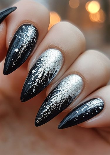 Elegant stiletto nails with black base and silver glitter gradient for a stunning look.