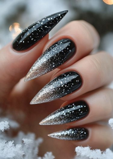 Elegant black and silver ombre stiletto nails with glitter, perfect for winter sophistication.