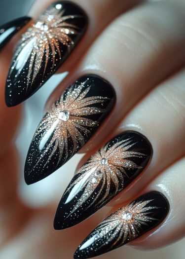 Elegant black stiletto nail art featuring gold glitter designs and rhinestones for chic occasions.