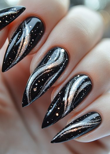 Elegant black stiletto nails with shimmering silver glitter art and cosmic details for a bold look.