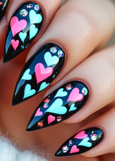 Stunning black stiletto nails adorned with colorful hearts and sparkling rhinestones.