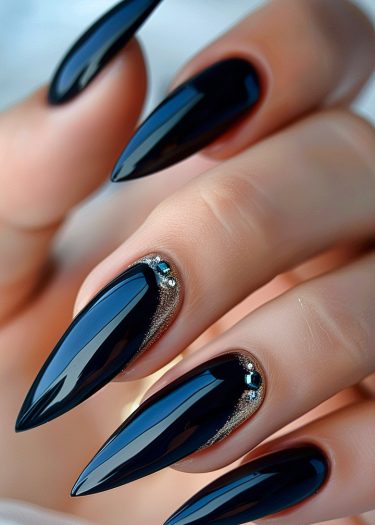 Glamorous black stiletto nails adorned with rhinestones for a stunning manicure statement.