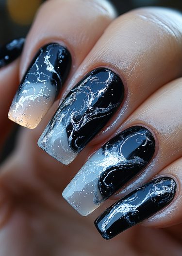 Elegant black and white marble nails with silver glitter for a sophisticated manicure look.