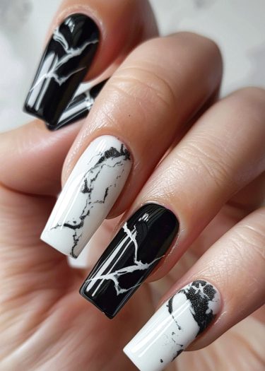 Elegant black and white marble nail art with striking contrast and intricate designs.