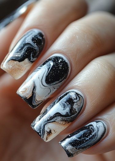 Elegant black and white marble nail design with glitter for a sophisticated manicure.