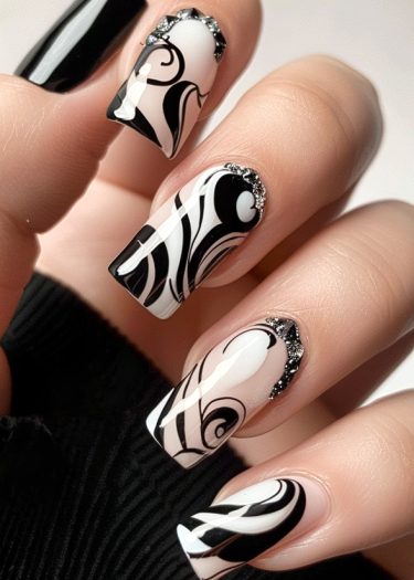 Elegant black and white nail art with silver rhinestones showcasing intricate designs and patterns.