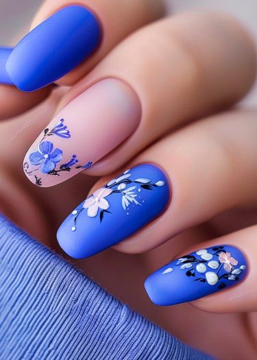 Vibrant matte blue and pink floral nail art design with intricate detailing.