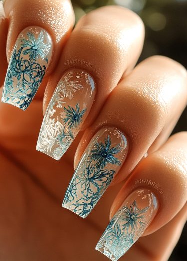 Elegant blue floral nail art on coffin-shaped nails with intricate designs and glossy finish.