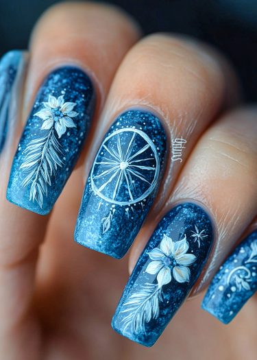 Elegant dark blue nail art featuring floral and feather designs on a celestial background.