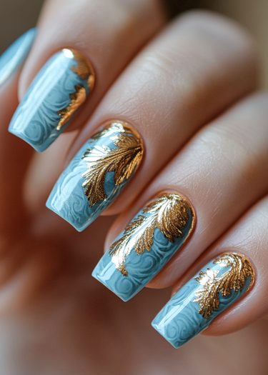 Elegant blue and gold nail art featuring intricate designs and a glossy finish.