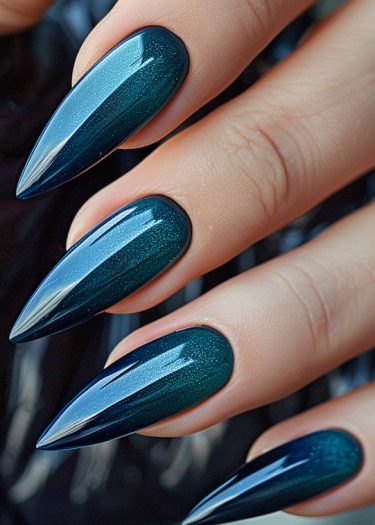 Gorgeous teal stiletto nails with gradient shimmer and a glossy finish on elegant hand.