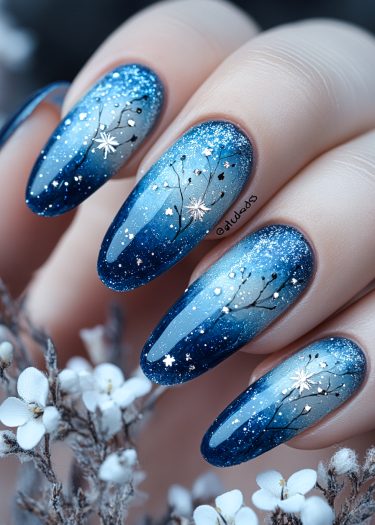 Enchanting winter-themed blue gradient nail art with stars and floral accents.