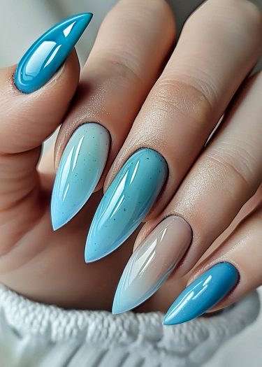 Glossy turquoise ombre stiletto nails showcase elegant nail art in a vibrant design.