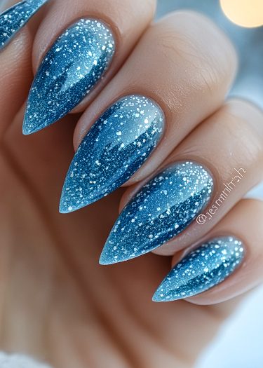 Elegant blue gradient stiletto nails with glitter, showcasing a stunning manicure design.