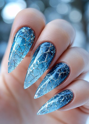 Stunning blue gradient stiletto nails with gold marble design showcase exquisite nail artistry.